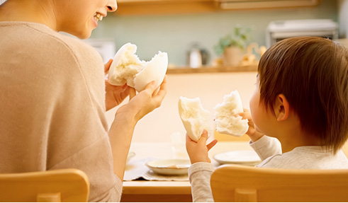 親子が白パンを持つ写真